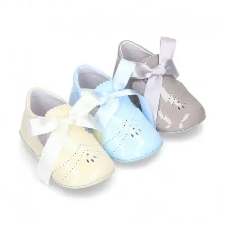Angelito para bebés con lengüeta y lazo en piel charol.