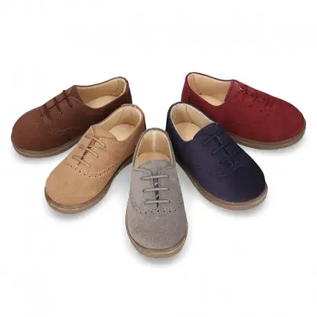 Zapato tipo BLUCHER con cordones y picados en piel serraje.